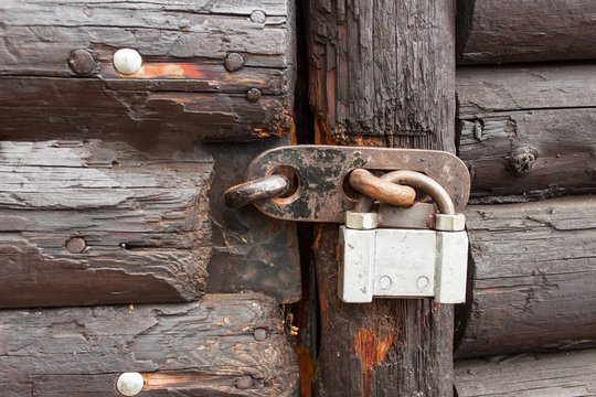 Old padlock on wooden doors. Property protection.