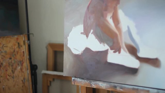 Paintbrushes on Art workroom background. Oil painting material close up. Pan. Gaining the paint brush with palette