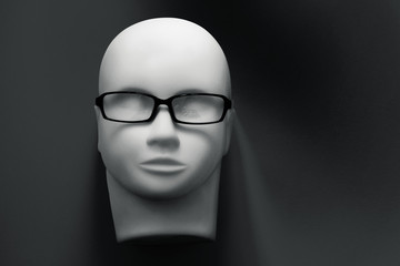mannequin head with black eyeglasses on background