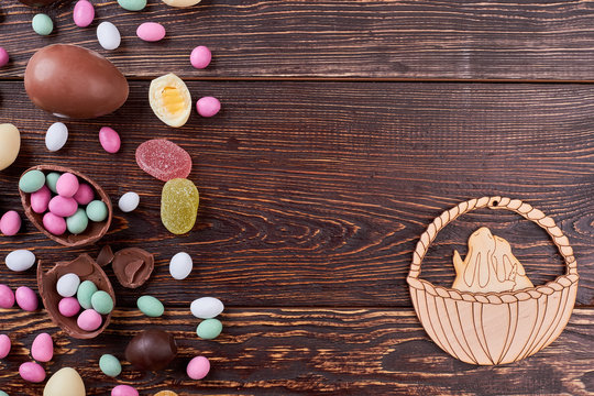 Candies on brown wood, copyspace. Rabbits in basket cutout.