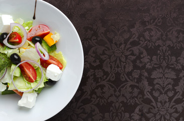 Vegetable salad on a white plate in a restaurant