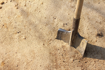working tool in the environment/ Old shovel with wooden handle stuck in the sand