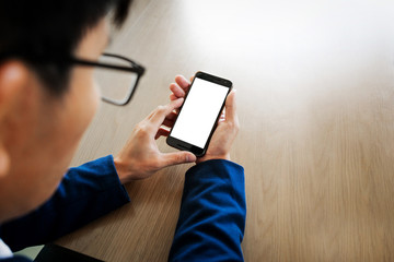 Close up of a businessman using mobile smart phone on wooden table, business concept.
