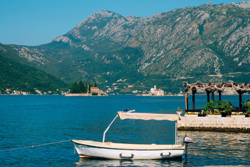 The old town of Perast on the shore of Kotor Bay, Montenegro. The ancient architecture of the Adriatic and the Balkans. Boats and yachts on the dock.