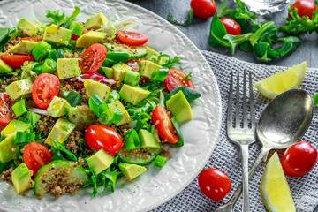 Quinoa tabbouleh salad with avocado, tomatoes, cucumber, green onion. Concept healthy food.