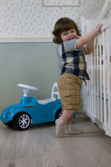 Fototapeta premium litle boy sit on a toy car