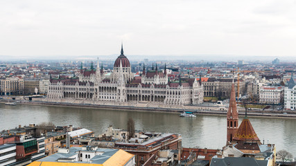 Obraz premium Cityscape of Budapest with hungarian parliament building on Danube river seen from the Buda side on a cloudy day