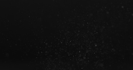 dust particles fast moving over black background from right, 4k photo - obrazy, fototapety, plakaty