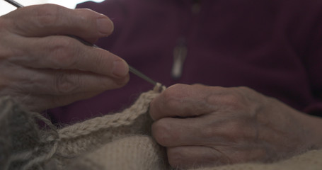 grandmother hands knitting sweater closeup, 4k photo