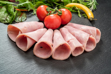 Sliced ham sausage on a stone background