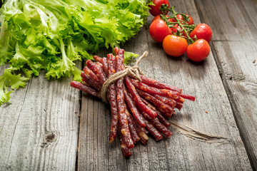 Food background. Snack stick sausages on a wooden table