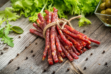 Food background. Snack stick sausages on a wooden table