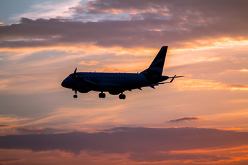 Airplane landing at sunset