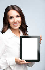 Businesswoman showing blank tablet pc, on grey