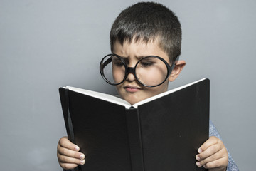 Tale, Boy with giant glasses reading a book with funny and varied gestures