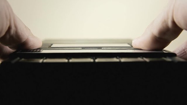 Inserting an audio cassette into a vintage player. Low POV macro close-up shot.

