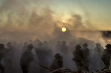Fototapeta premium War Concept. Military silhouettes and tanks fighting scene on war fog sky background, World War Soldiers Silhouettes Below Cloudy Skyline At Dusk or Dawn. Attack scene