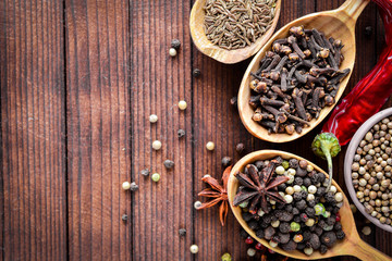 A mixture of spices. Wooden spoon. On Wooden background. Top view.