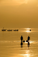 Silhouette of fisherman going to the sea in the morning