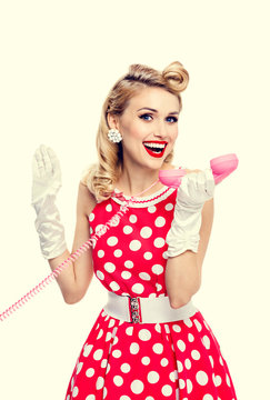 smiling woman with phone, dressed in pin-up style dress
