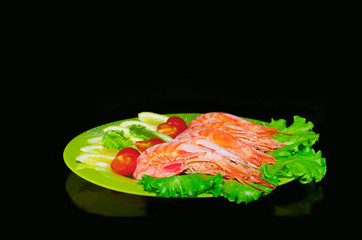 Lobster with tomato and lemon, on a plate and black background