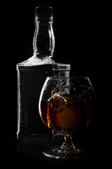 brandy or whiskey pouring into glass on a black background