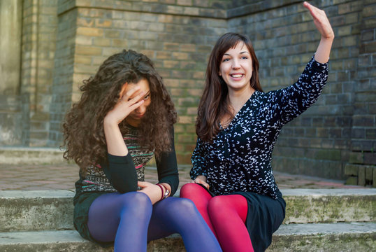 Two sisters sit outside and talk