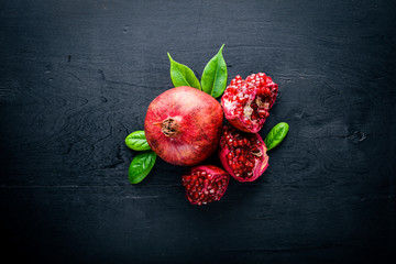 Fresh pomegranate on a dark Wooden surface. Top view.