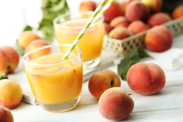 Glasses of peach juice on white wooden table