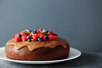Homemade chocolate cake with berries on grey wooden table
