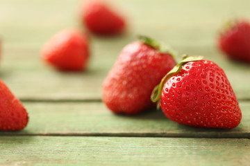 Fresh and tasty strawberries on a green wooden table