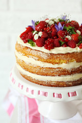 Delicious biscuit cake with berries on cake stand