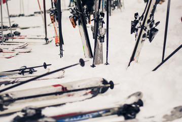 Skis and poles are left in the snow, a lot of them, while people are resting in the warm cafes with hot coffee