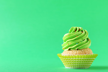 Tasty cupcake on a green background