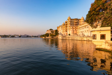 Udaipur cityscape at sunset. The majestic city palace on Lake Pichola, travel destination in Rajasthan, India