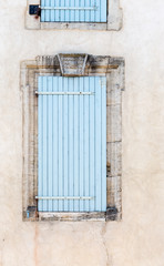 Fototapeta na wymiar Old vintage rustic blue closed windows shutters French style architecture