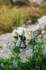 Wedding bridal bouquet of Lisianthus and Cineraria silver on the rocks. Wedding in Montenegro, Adriatic.