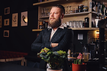 A man dressed in a suit at the counter in a coffee shop.