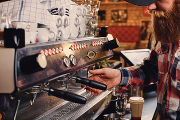  Close up image of a man making coffee.