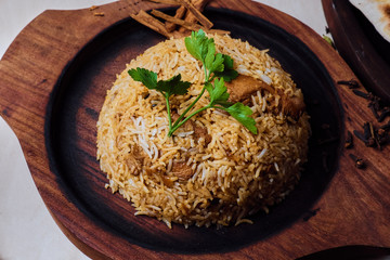 Brown rice with herbs on a wooden plate.