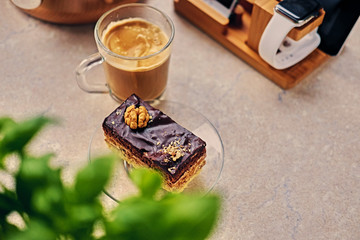 Sweet, delicious cake, herbs and cop of coffee on a table.