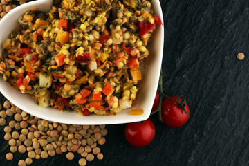 Lentil with carrot and pumpkin ragout in a wooden bowl on a wood