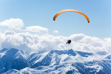 Gardinen Parachute sky-diver flying in clouds above mountains. Travel adventure concept. space for text © muzhchil