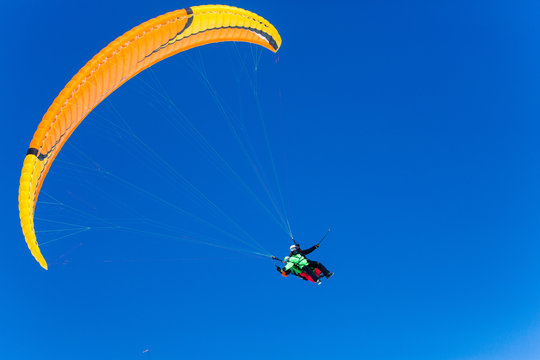 Parachute sky-diver flying in clouds above mountains. Travel adventure concept. space for text