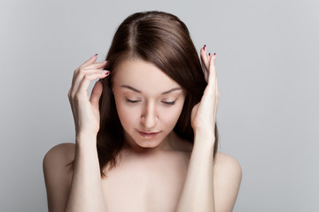 Isolated on gray background studio portrait of young brunette with manicure on nails