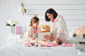 Mother is reading a book with her daughter
