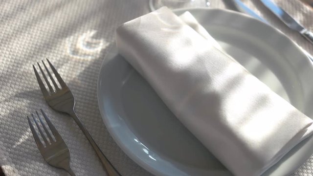 White plate with napkin. Silverware on tablecloth. Restaurant with best service.