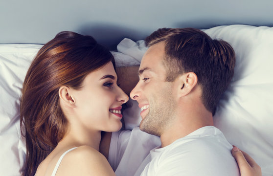 Young couple hugging on the bed in bedroom
