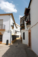 Fototapeta premium Spain. Andalucia. Ronda. Street of town with white houses, vertical view.