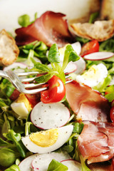 fresh salad with ham and boiled eggs on a rustic pan. Healthy lifestyle concept.